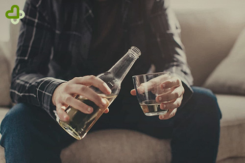 Мужчина наливает алкоголь в стакан